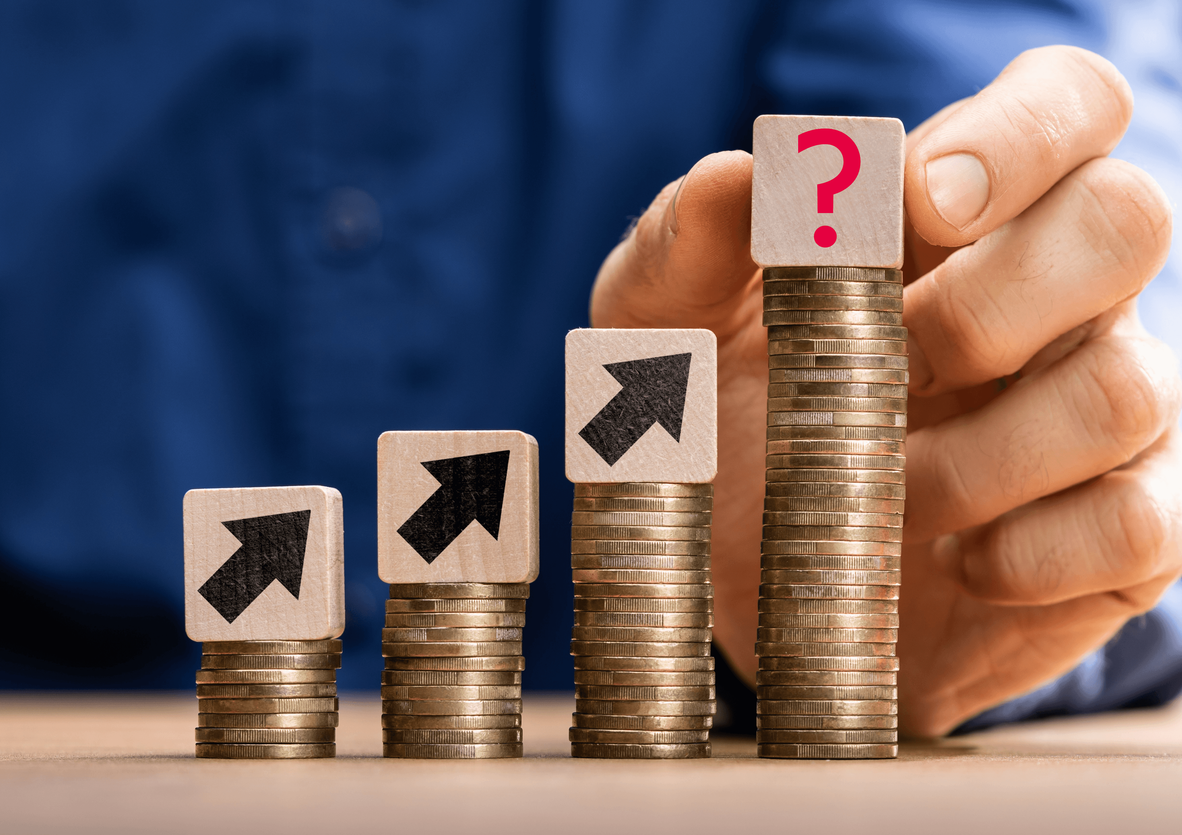 Vier Stapel aus Münzen und auf jedem der Münzstapel ein Pfeil der schräg nach oben rechts zeigt. Auf dem letzten und höchsten Stapel steht ein Würfel mit einem Fragezeichen.