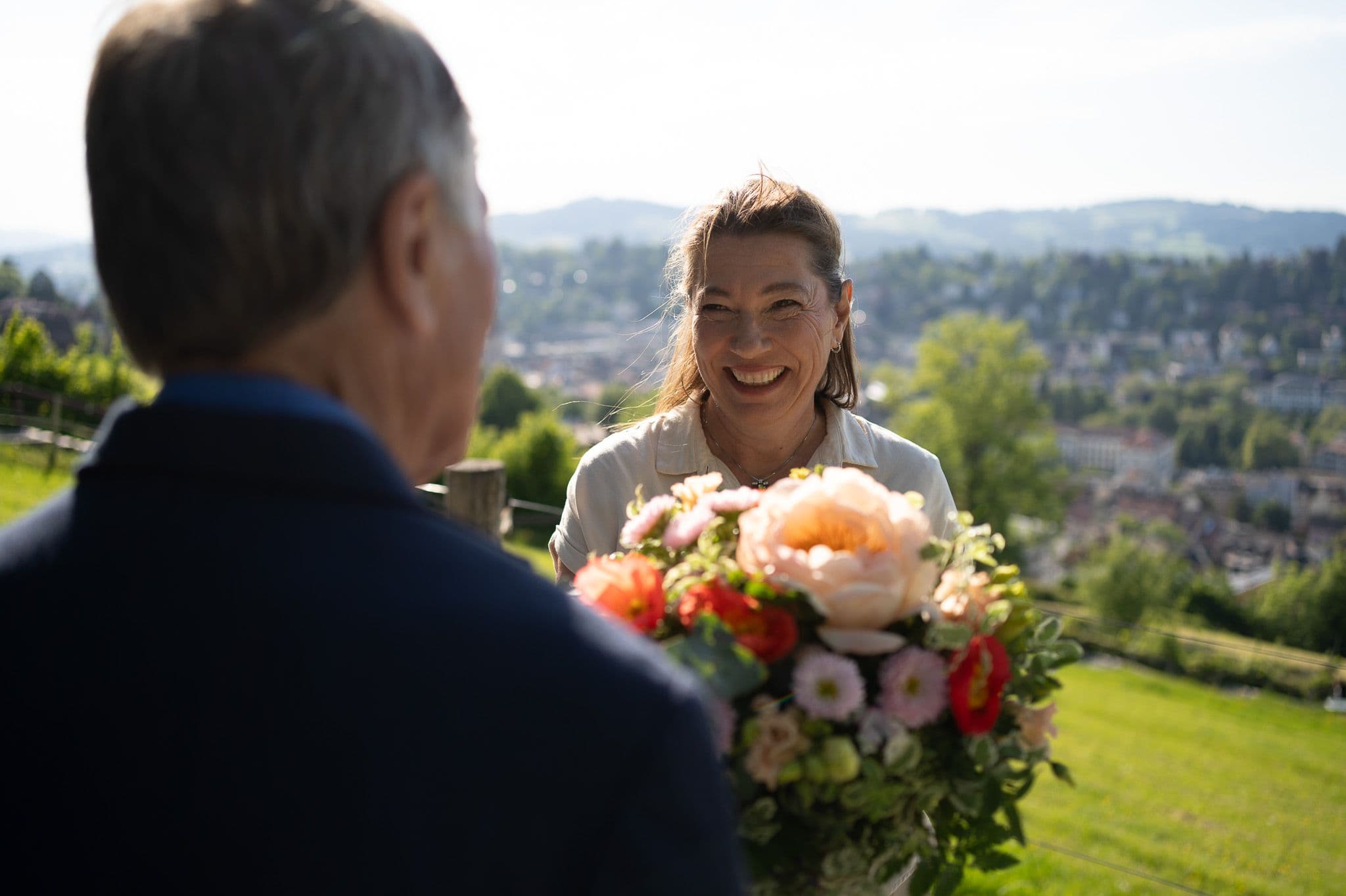Zwei Menschen, eine hält einen Blumenstrauss